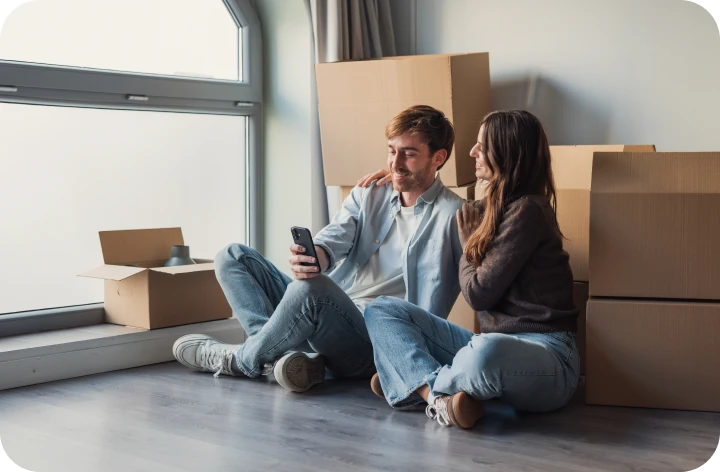 Couple sitting on the floor among moving boxes
