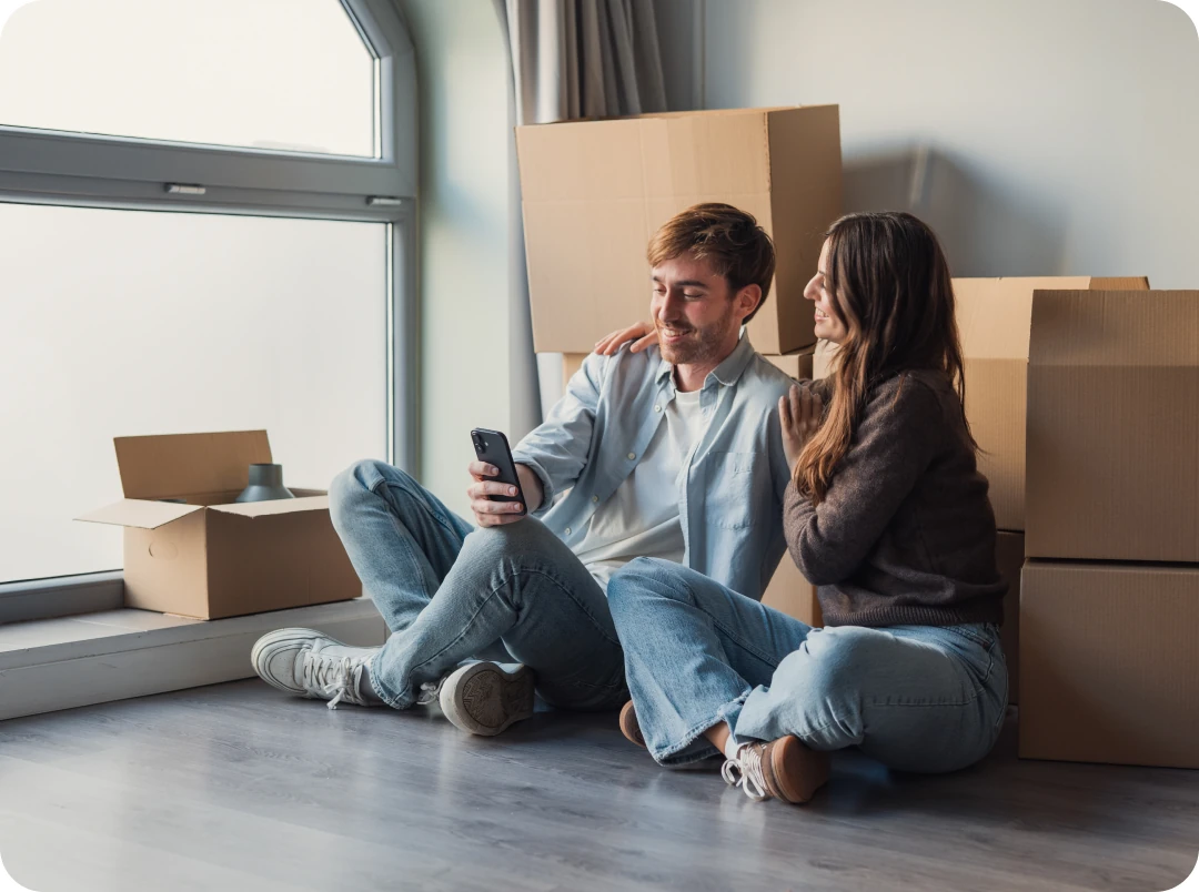Couple sitting on the floor among moving boxes